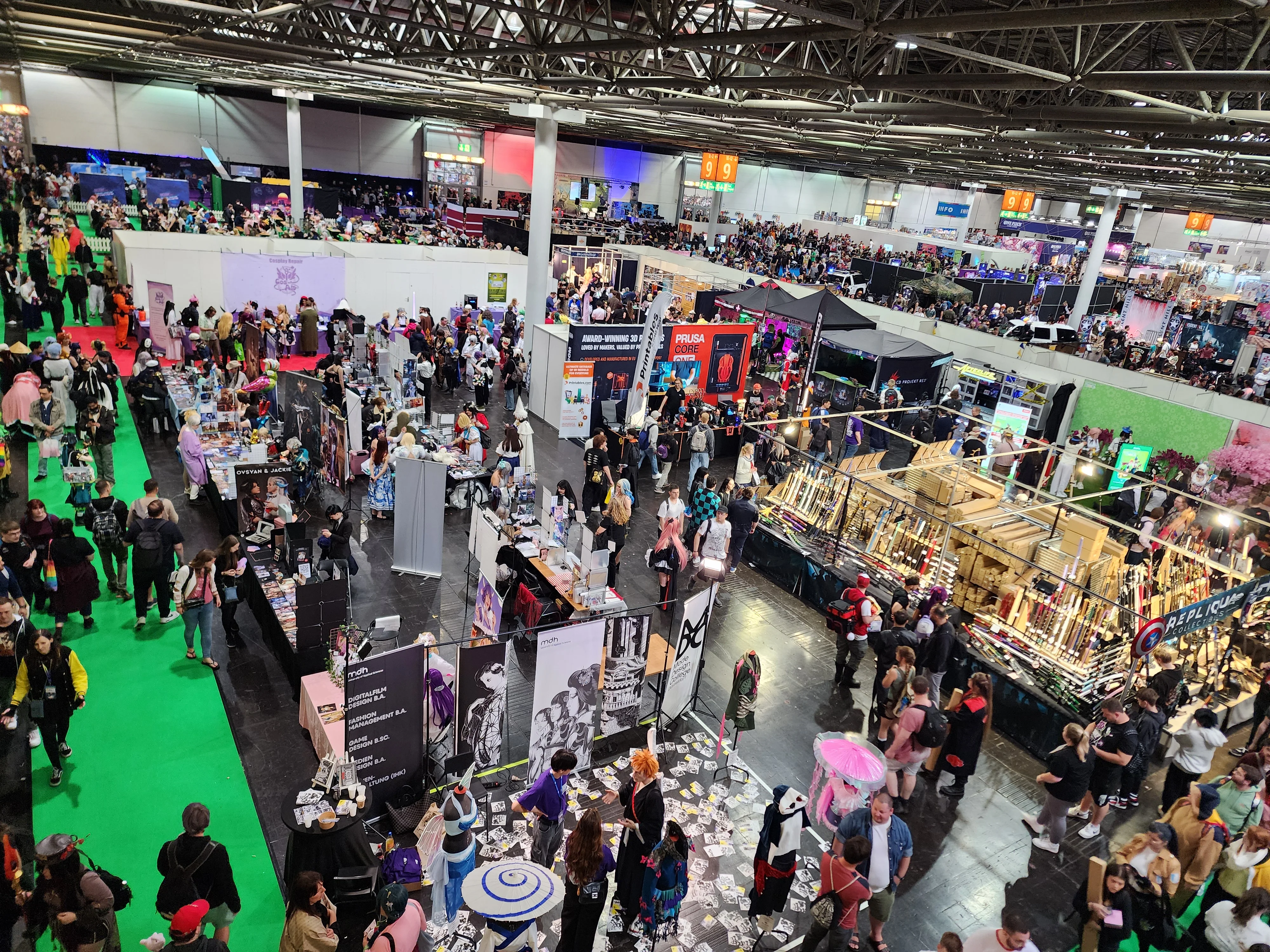 Convention hall floor with attendees and exhibitor booths