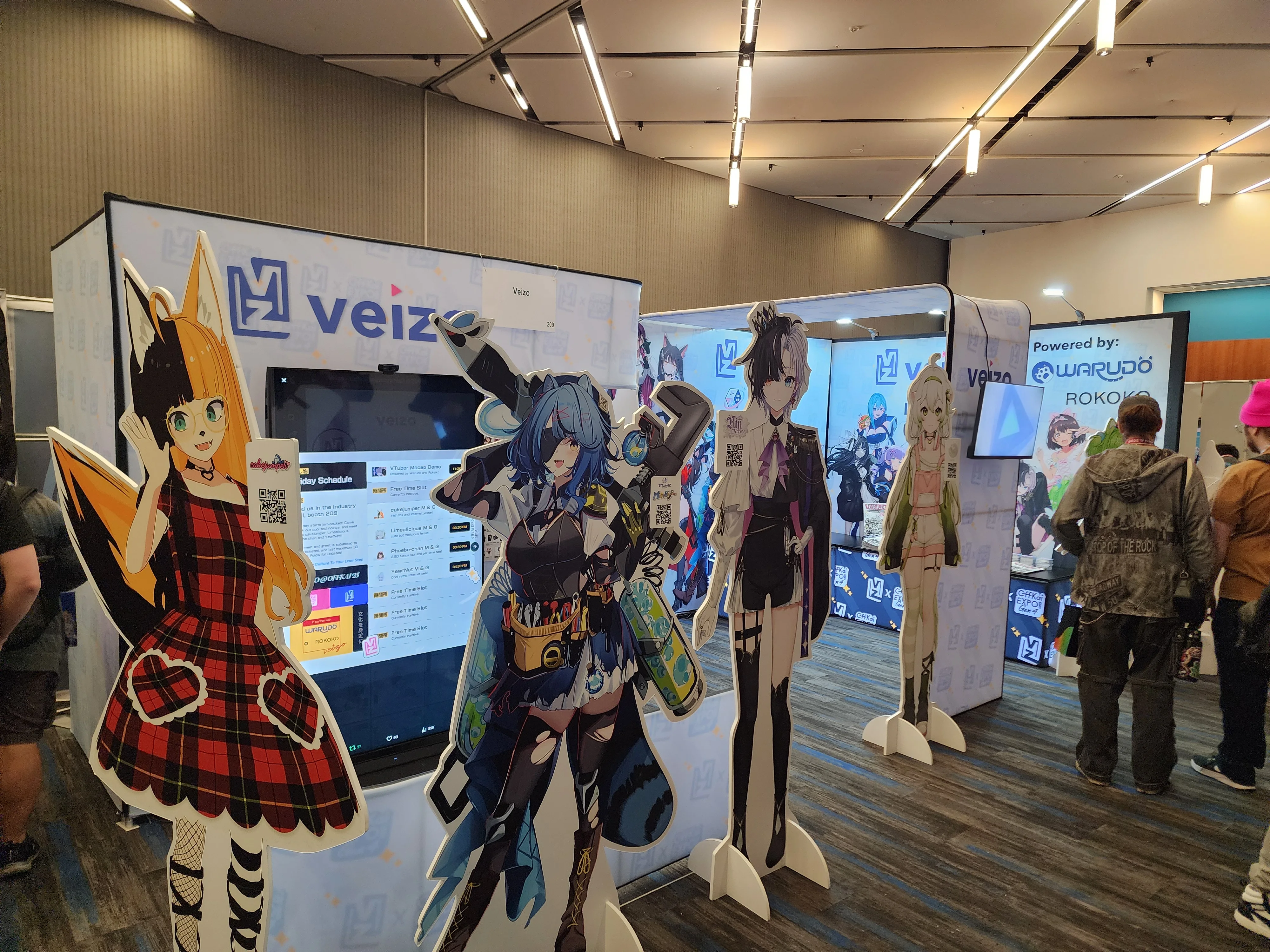 Veizo exhibition booth at OffKai with VTuber standees and branded displays